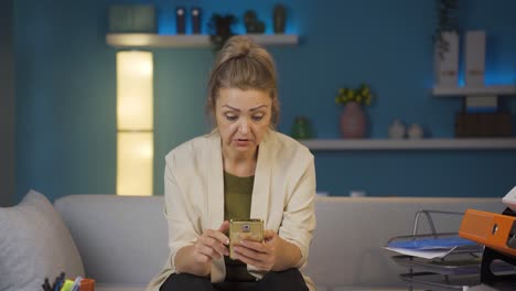 Woman-working-from-home-enjoys-mobile-apps-on-phone.